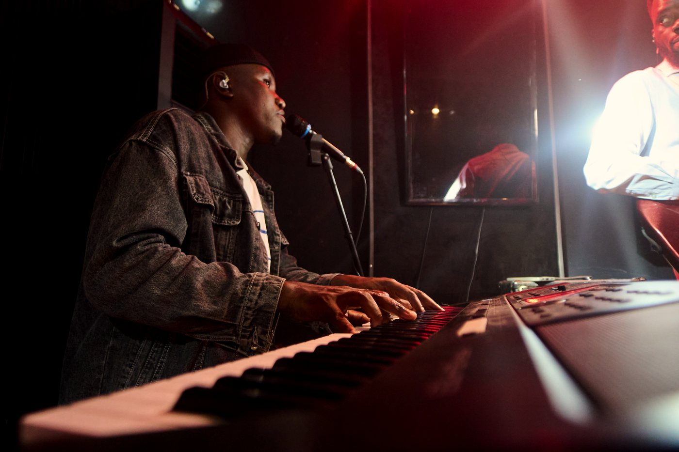 The keys player singing into a microphone while playing.